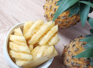 Slice of pineapple and whole pineapple on the background