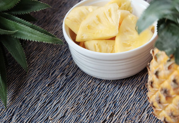 Slice of pineapple and whole pineapple on the background