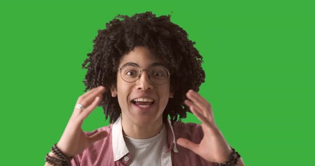 Happily surprised man with hands to head in disbelief over green chroma key background