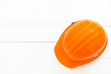 Engineer or foreman safety helmet on white wooden background.