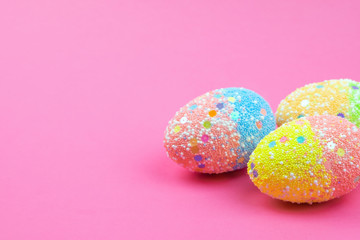 A lot of colorful Easter eggs on a pink background. Place for text.