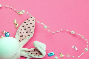 Easter bunny white egg with pink ears in black peas. 