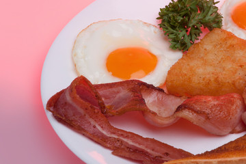 Plate with eggs and meats near rolls