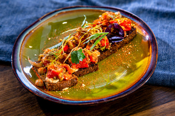 Vegan sandwiches with grilled vegetables and cheese on fried craft bread. European cuisine. The work of a professional chef. Dish from a restaurant or cafe menu. Close-up