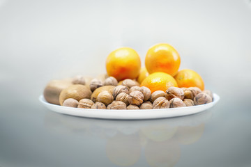 Walnuts, kiwi and oranges on a white plate