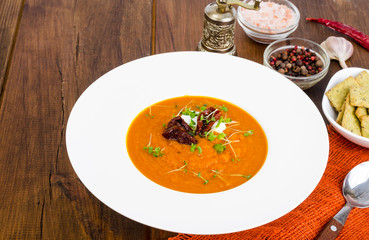 Delicious vegetable cream soup with tomatoes and microgreens.