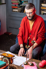 Bearded mature magician predicting future in the living room