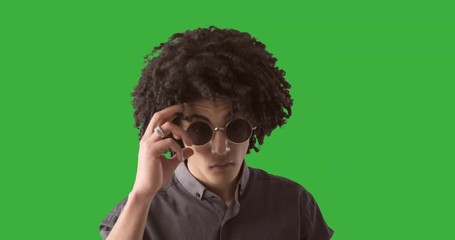 Handsome young man checking his look over green chroma key background