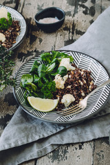 Roasted Cauliflower and Red Quinoa Salad with Pine Nuts on a wooden background, selective focus