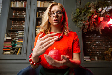 Astrologist closing eyes and breathing slowly while holding candle