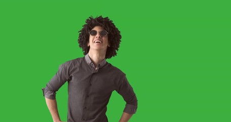 Handsome man pointing with his finger over green chroma key background