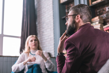 Fototapeta premium Bearded man feeling thoughtful answering questions of psychologist