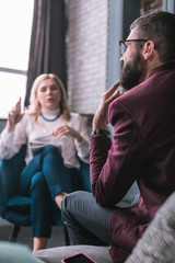 Obraz premium Bearded man feeling worried explaining problems to psychologist