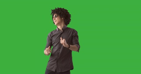 Handsome young man dancing in slow motion over green background