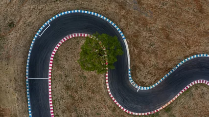 Foto op Plexiglas Gebogen racebaanweergave van bovenaf, luchtfoto autorace asfaltbaan en curve. © Kalyakan