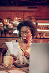 Portrait of african-american girl holding paper pieces and pen