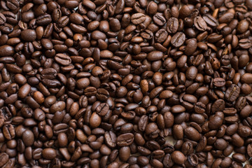 Texture of coffee beans scattered randomly. Brown texture.