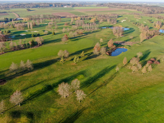 Aerial view of a golf course. Beautiful colorful trees and green course during autumn/winter season in the South of Belgium, Walloon Brabant.