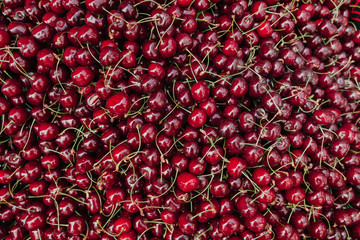 Ripe red sweet cherry lies in even layer