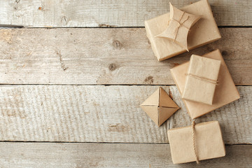 Wrapped christmas presents in paper craft package on vintage wooden background, copy space. stylish gifts, seasonal greetings, concept of holiday preparation