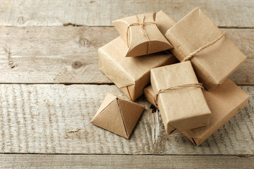 Wrapped christmas presents in paper craft package on vintage wooden background, copy space. stylish gifts, seasonal greetings, concept of holiday preparation