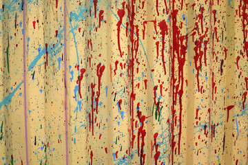 the texture of the painted fence.  yellow background with red spots