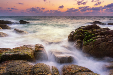 Beautiful natural seascape wave hit the rock during sunset