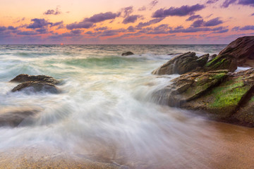 Beautiful natural seascape wave hit the rock during sunset
