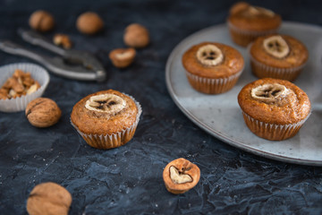 Homemade Walnut and banana muffins on dark background. Side view