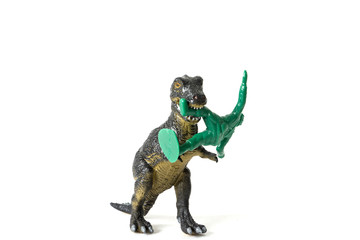 plastic dinosaur fighting with a toy soldier