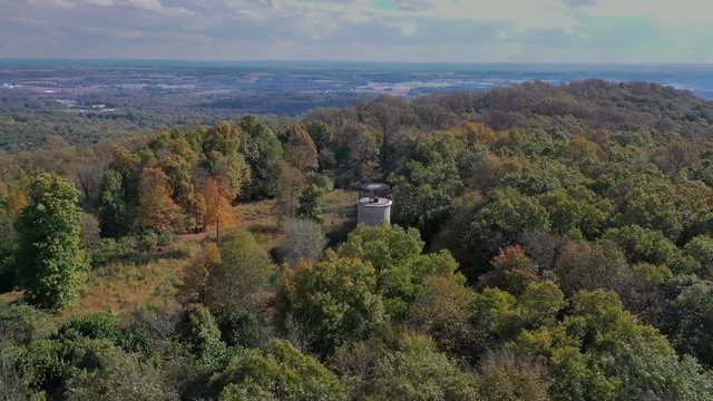 Aerial pan of observation tower on top of mountain, dense woods surrounding the scene, Governor Dick observation tower in Lebanon County, PA