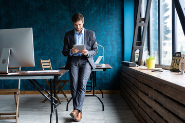 Handsome elegant businessman working on a tablet.