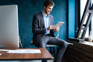 Handsome elegant businessman working on a tablet.
