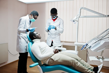 African american man patient in dental chair. Dentist office and doctor practice concept. Professional dentist helping his patient at dentistry medical. Injection anesthetic.