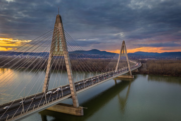 Fototapeta na wymiar Budapest, Hungary - Aerial view of Megyeri Bridge over River Danube at sunset with heavy traffic and beautiful sky and clouds