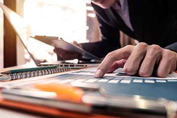 businessman hand using smart phone, tablet payments and holding credit card online shopping, omni channel, digital tablet docking keyboard computer at office in sun light