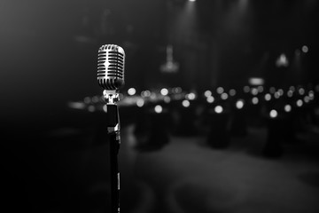 stylish 50s or 60s retro rock microphone on an empty venue stage. Vintage mic at a live band show - obrazy, fototapety, plakaty