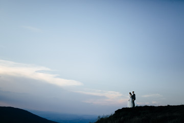 Beautiful wedding couple, bride and groom, in love on the background of mountains