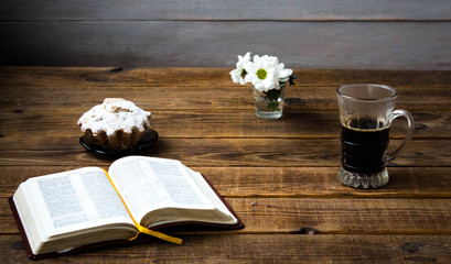a coffee cupcake flowers and a book on a wooden background