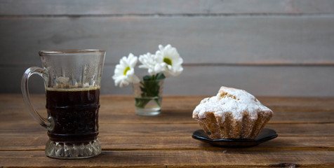 coffee cupcake and flowers on a wooden background