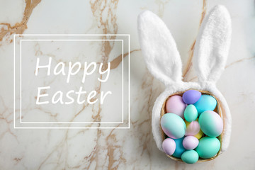 Beautiful Easter eggs and bunny ears on light background