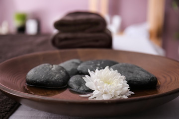 Spa stones and beautiful flower on plate