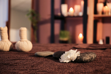 Massage stones and flower on table in spa salon