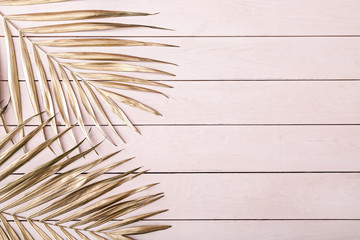 Obraz premium Painted golden tropical leaves on wooden background