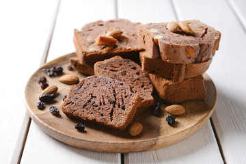 Plate with pieces of tasty chocolate cake on white table