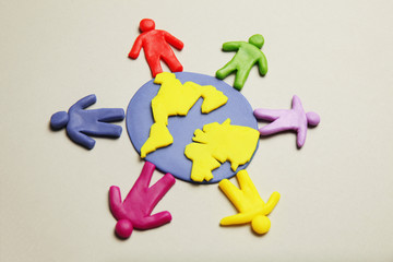 Plasticine figurines of people of different races are on planet earth. A variety of interactions, communication and globalization. Cartoon art.