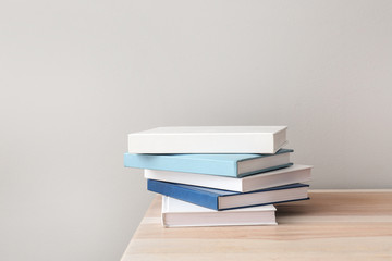 Many books on table against light background