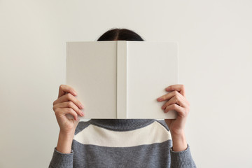 Woman with book on light background