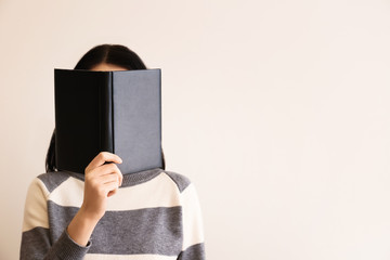 Woman with book on light background