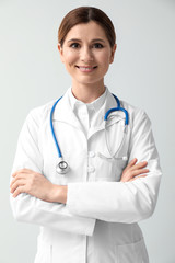 Beautiful female doctor on light background